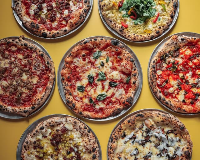 Several pizzas next to each other on a table